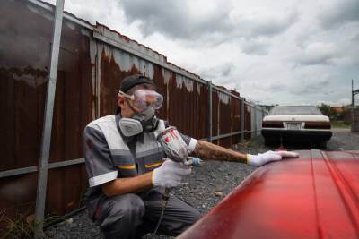 Side view man painting car door