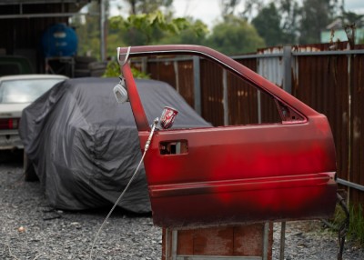 Spraying powder paint concept with red door